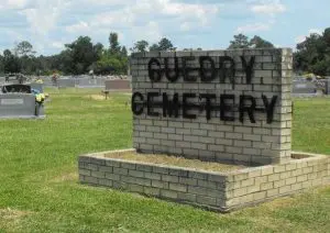 A sign that says guedry cemetery in brick.